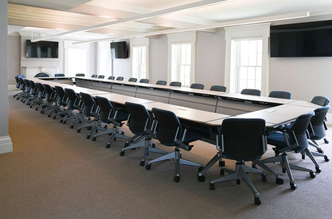 Actual hotel meeting room before editing, arranged in a U-shape with rolling chairs